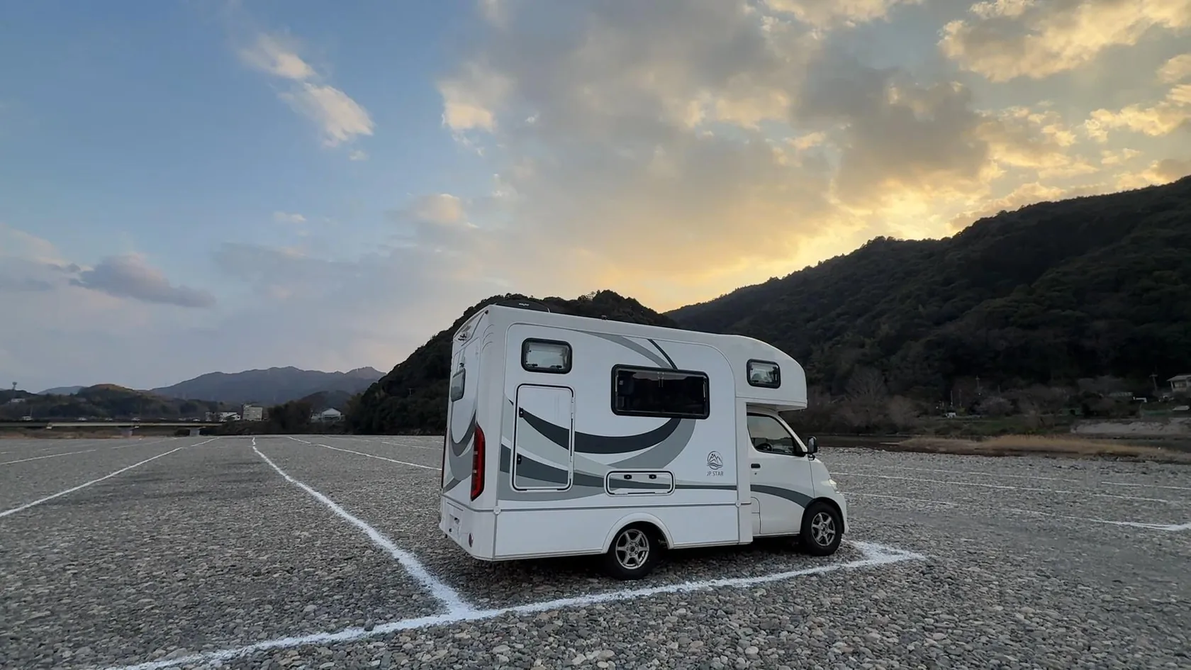 夕空の下に停まる家族のキャンピングカー